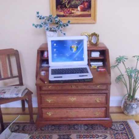 Geöffneter Laptop in 1 zu 12 auf einem Miniatur-Schreibsekretär 